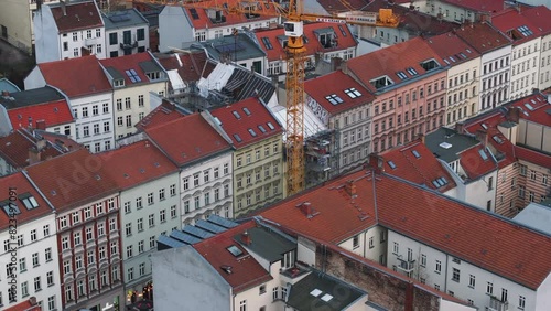 Aerial view of a crane in a construction site surrounded by buildings with red roofs and classical german architecture in a residential area of the city in Prenzlauer Berg district, Berlin photo