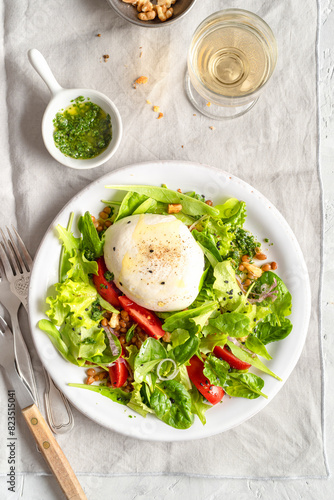 Italian salad: seome ingredients are salad, tomato slices, walnuts, mozzarella, olive oil, lentils and pepper.