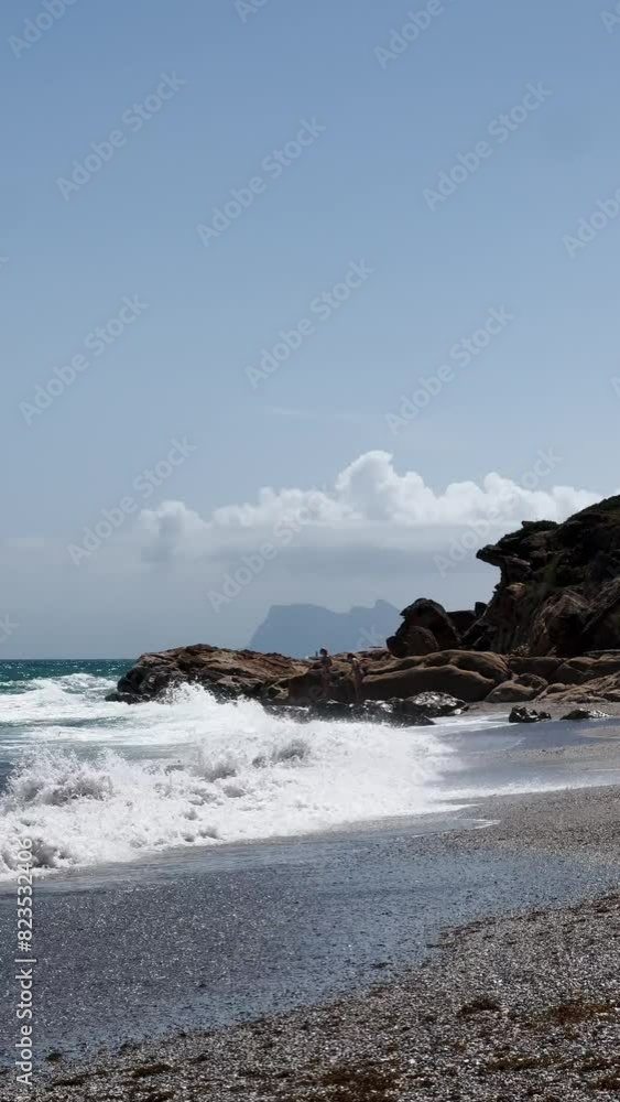 A beautiful coastal landscape with waves crashing against large rock formations under a clear sky, sotogrande, spain, andalusia, gibraltar A beautiful coastal landscape with waves crashing against large rock formations under a clear sky, sotogrande, spain, andalusia, gibraltar