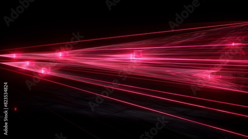 Abstract and artistic, this image captures red laser streaks speeding across a pitch-black background photo