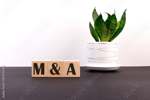 The concept of mergers and acquisitions. The inscription on wooden cubes photo