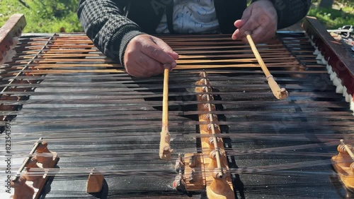 Street performer playing Iranian Santoor musical instrument, slow motion photo