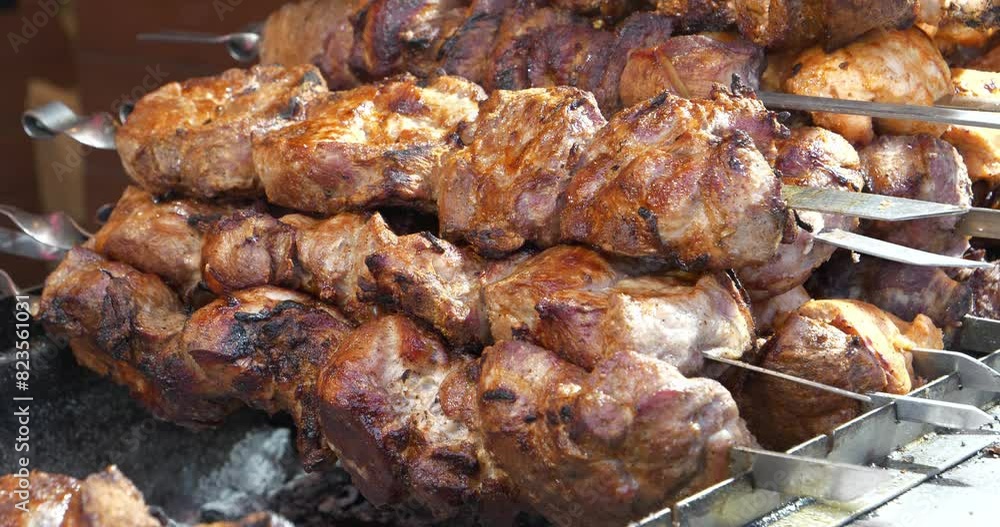 Shish kebab meat on skewers. Fatty, unhealthy, partially burnt meat with cholesterol and carcinogens. Meat are cooked on hot coals in chargrill or charcoal brazier Shish kebab meat on skewers. Fatty, unhealthy, partially burnt meat with cholesterol and carcinogens. Meat are cooked on hot coals in chargrill or charcoal brazier