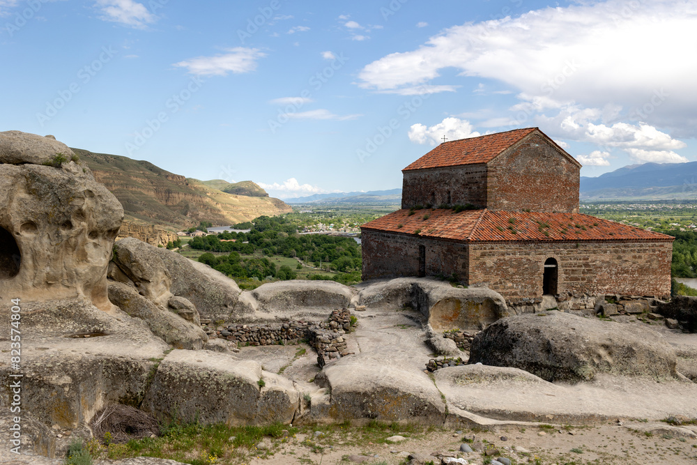 Fototapeta premium Uplistsikhe, Georgia, View of Ancient Cave Town and Church in Georgia with beautiful landscape