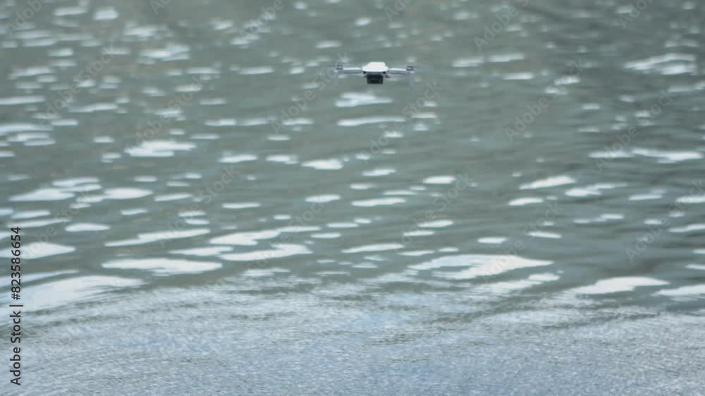 Drone flying above the lake making ripples in the water