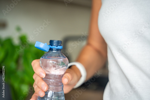 Tablou pe pânză Bottle with stationary plastic cap in woman hand