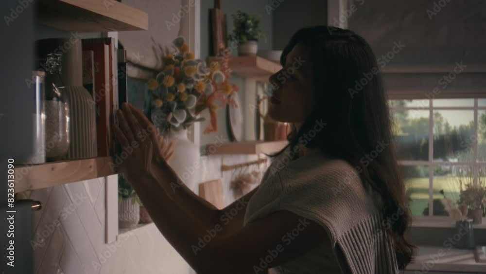 attractive woman in home kitchen, walking looking for a recipe book. writing and reading. attractive woman in home kitchen, walking looking for a recipe book. writing and reading.