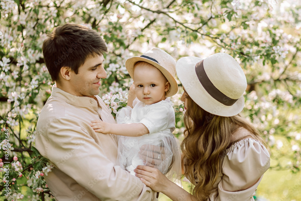Beautiful mother and daughter in hat with father on picnic Beautiful mother and daughter in hat with father on picnic