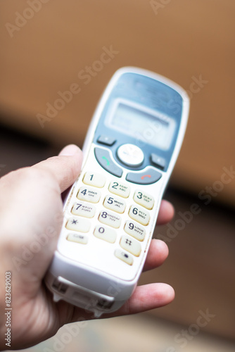 Person holding a communication device with the number 1 displayed on the screen