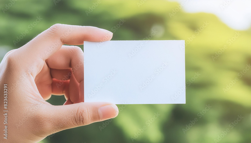 Hand holding mock-up of empty white business card, blurred natural background. Branding presentation Hand holding mock-up of empty white business card, blurred natural background. Branding presentation