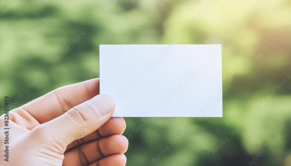 Hand holding mock-up of empty white business card, blurred natural background. Branding presentation Hand holding mock-up of empty white business card, blurred natural background. Branding presentation