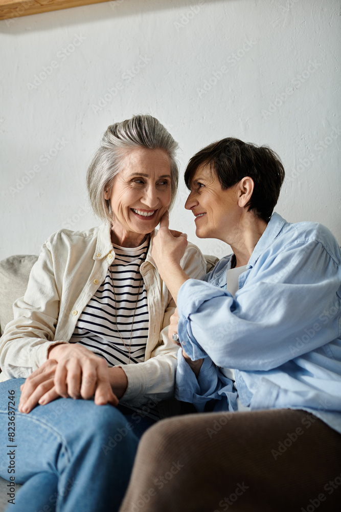Two women, a mature lesbian couple, engage in a heartfelt conversation on a cozy couch. Two women, a mature lesbian couple, engage in a heartfelt conversation on a cozy couch.