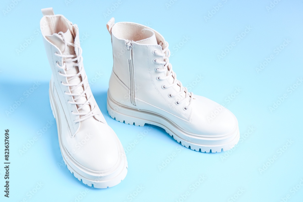 White demi-season martens boots with a bouquet of spring flowers on a light blue. White demi-season martens boots with a bouquet of spring flowers on a light blue.