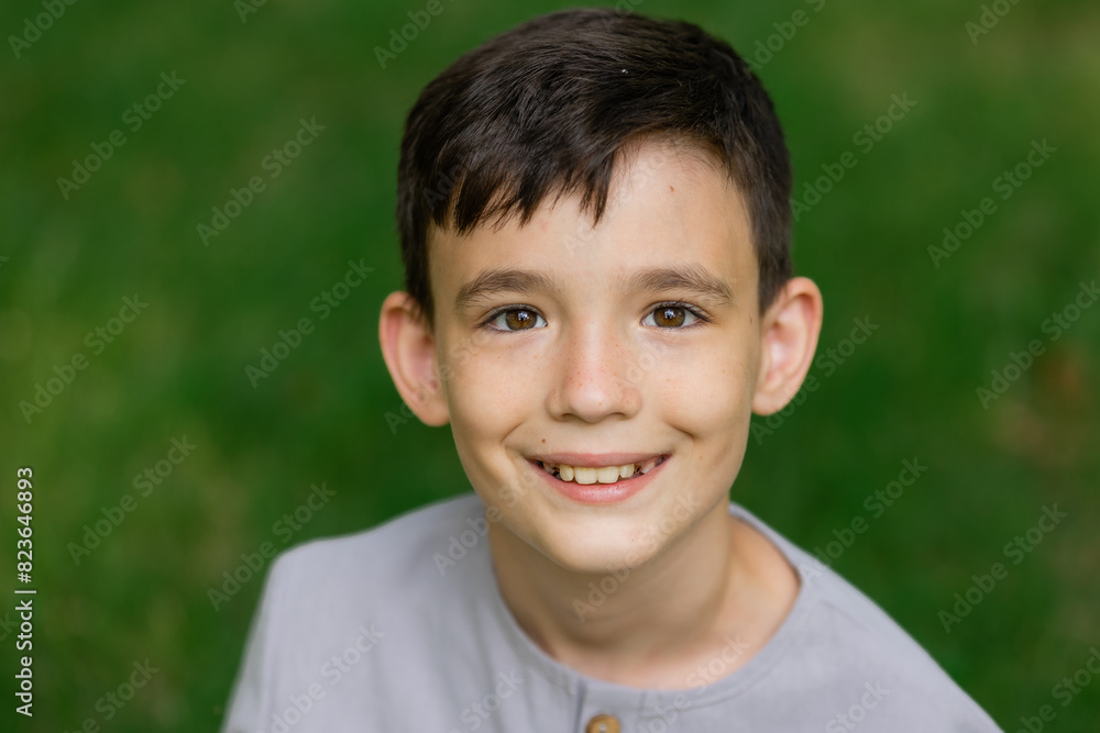Portrait of a little boy on a green lawn laughing, looking at the camera, Portrait of a little boy on a green lawn laughing, looking at the camera,