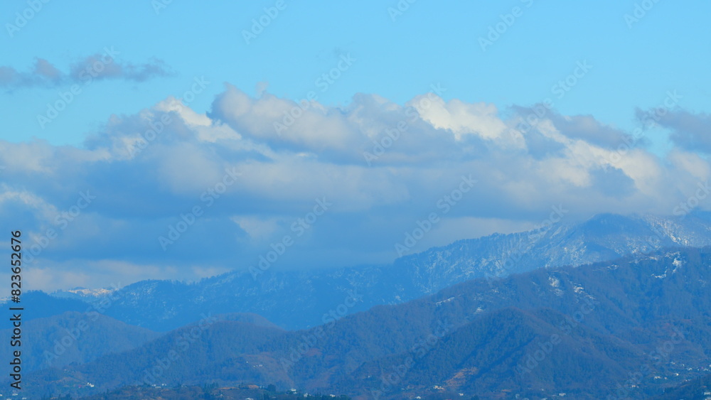 Mountain Landscape Under A Blue Sky. Showcases The Mesmerizing Sight Of Floating Clouds Against The Background Of Mountain.