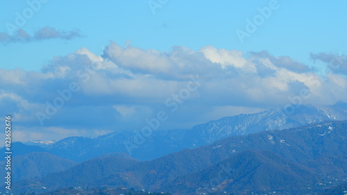Mountain Landscape Under A Blue Sky. Showcases The Mesmerizing Sight Of Floating Clouds Against The Background Of Mountain.