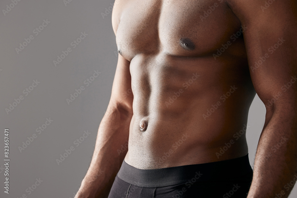 Abdomen, muscle and man in studio for fitness, exercise and body health closeup isolated on white background. Abs, shirtless and strong bodybuilder workout for energy, sport or power for wellness