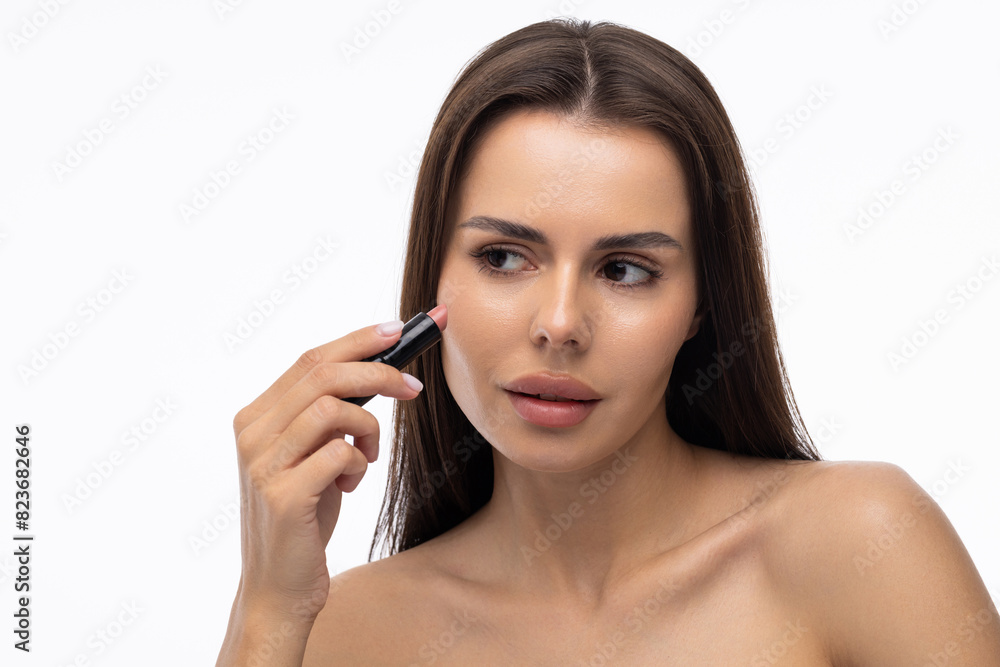 Young woman apply a lip gloss on her lips on white background Young woman apply a lip gloss on her lips on white background