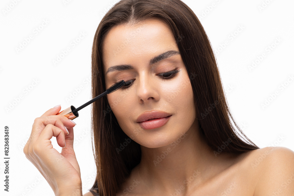 Young woman putting eye liner on eyelid on white background Young woman putting eye liner on eyelid on white background