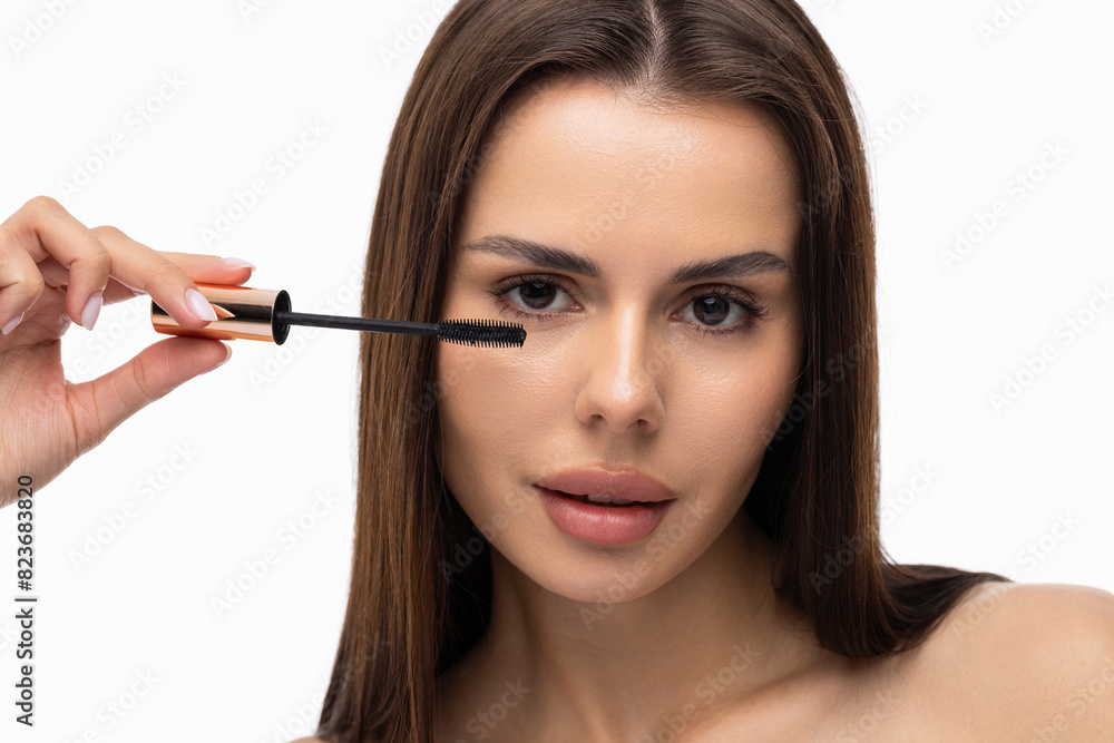 Young woman putting eye liner on eyelid on white background Young woman putting eye liner on eyelid on white background
