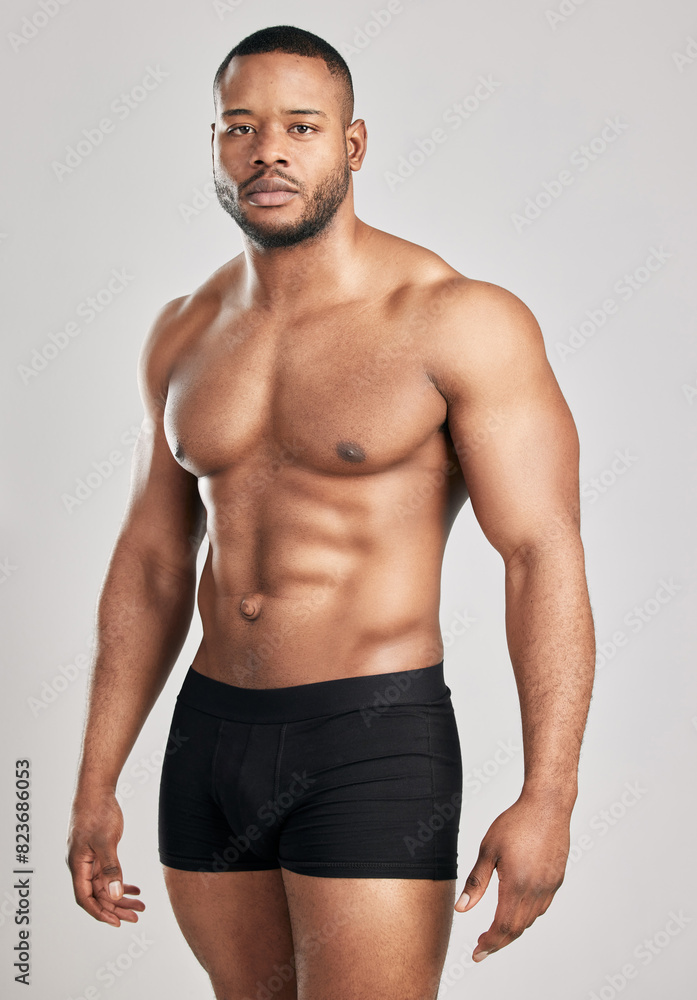 Portrait, black man and muscle in studio with underwear for fitness or health with confidence for body. Strength, serious and ready for bodybuilding competition in Germany with power training.