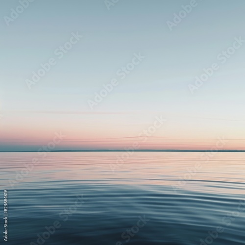 A calm body of water with a beautiful pink and orange sky in the background