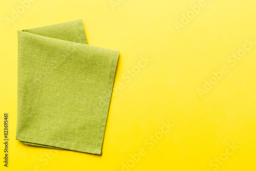 top view with green kitchen napkin isolated on table background. Folded cloth for mockup with copy space, Flat lay. Minimal style