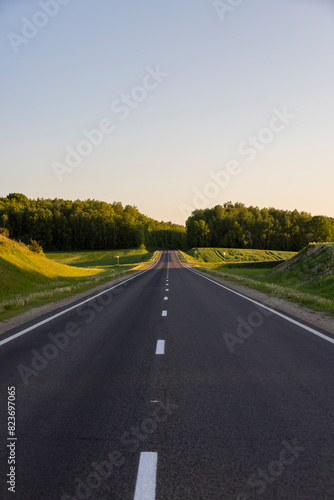 a colored sky at sunset and an empty highway