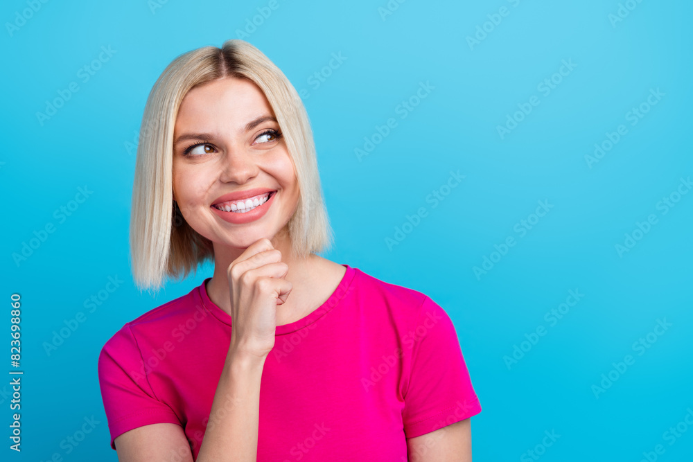Photo portrait of lovely young lady minded look empty space dressed stylish pink clothes isolated on blue color background Photo portrait of lovely young lady minded look empty space dressed stylish pink clothes isolated on blue color background