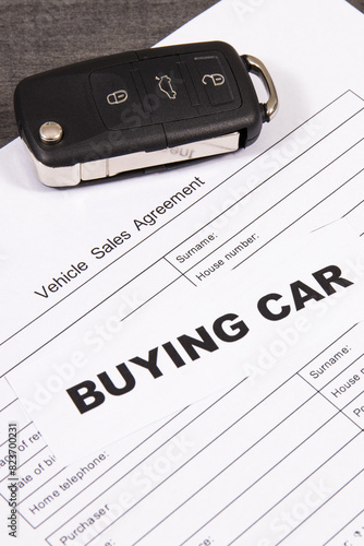 Car key, inscription buying car and form of vehicle sales agreement. Sales or purchases new or used vehicle