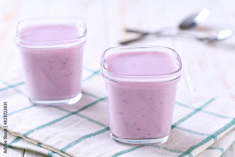 homemade fruit yogurt in a glass jars on a white table, selective focus. homemade fruit yogurt in a glass jars on a white table, selective focus.
