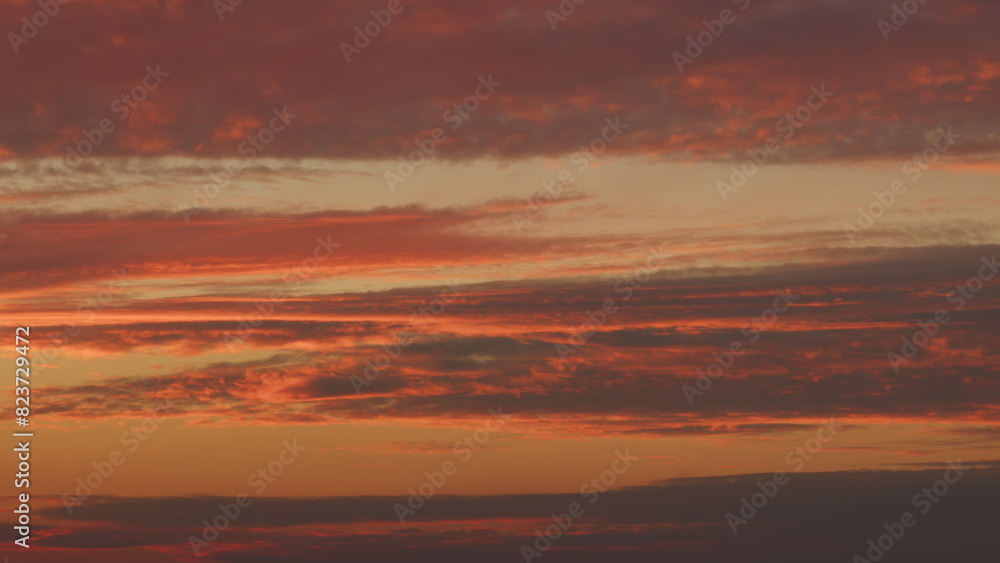 Intense dramatic panoramic sunset. Abstract different shades clouds at sunset sky background. Timelapse.