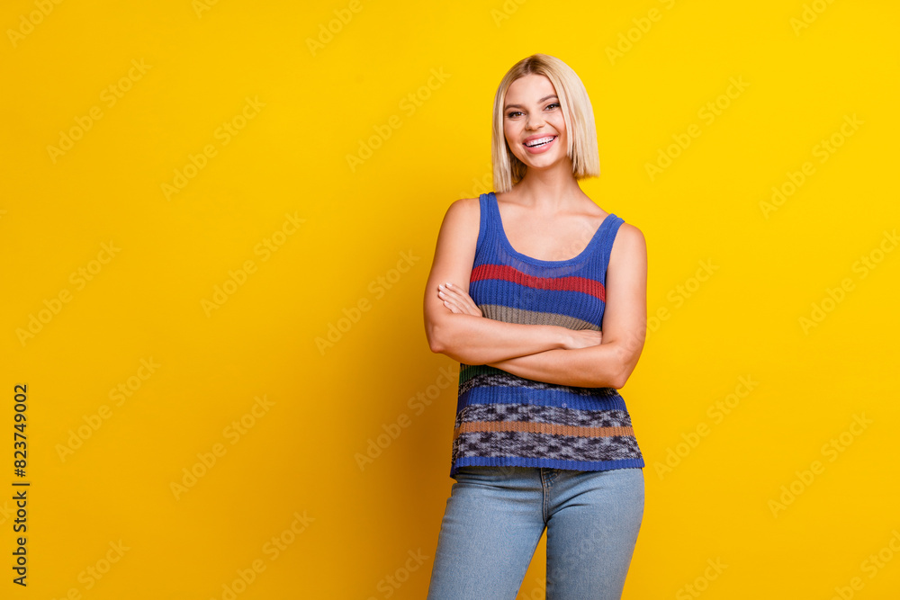 Photo portrait of young toothy smiling cute beautiful satisfied woman student in singlet folded hands isolated on yellow color background Photo portrait of young toothy smiling cute beautiful satisfied woman student in singlet folded hands isolated on yellow color background