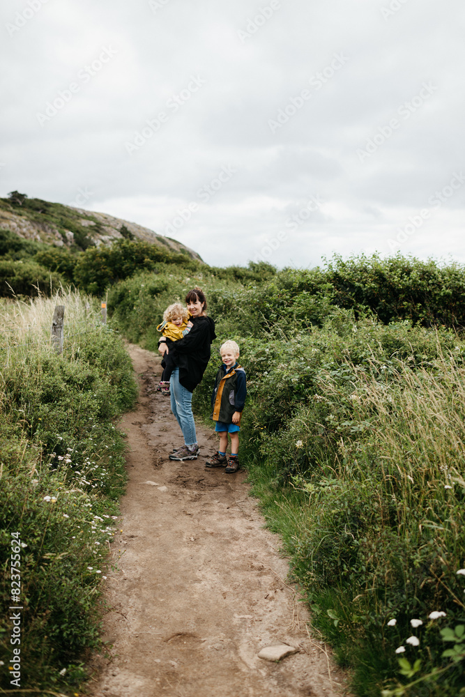 Mother and children hiking on a trail Mother and children hiking on a trail
