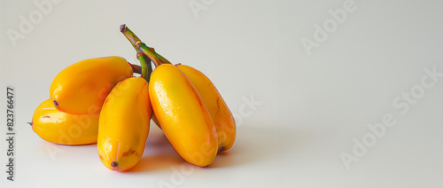 A bunch of yellow bananas are sitting on a white background. The bananas are ripe and ready to eat. ipe yellow fruits on white background photo