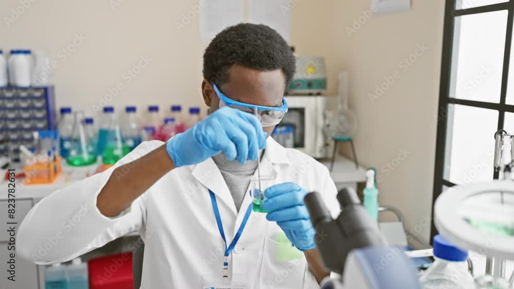 African man scientist analyzing green liquid in a laboratory indoors African man scientist analyzing green liquid in a laboratory indoors