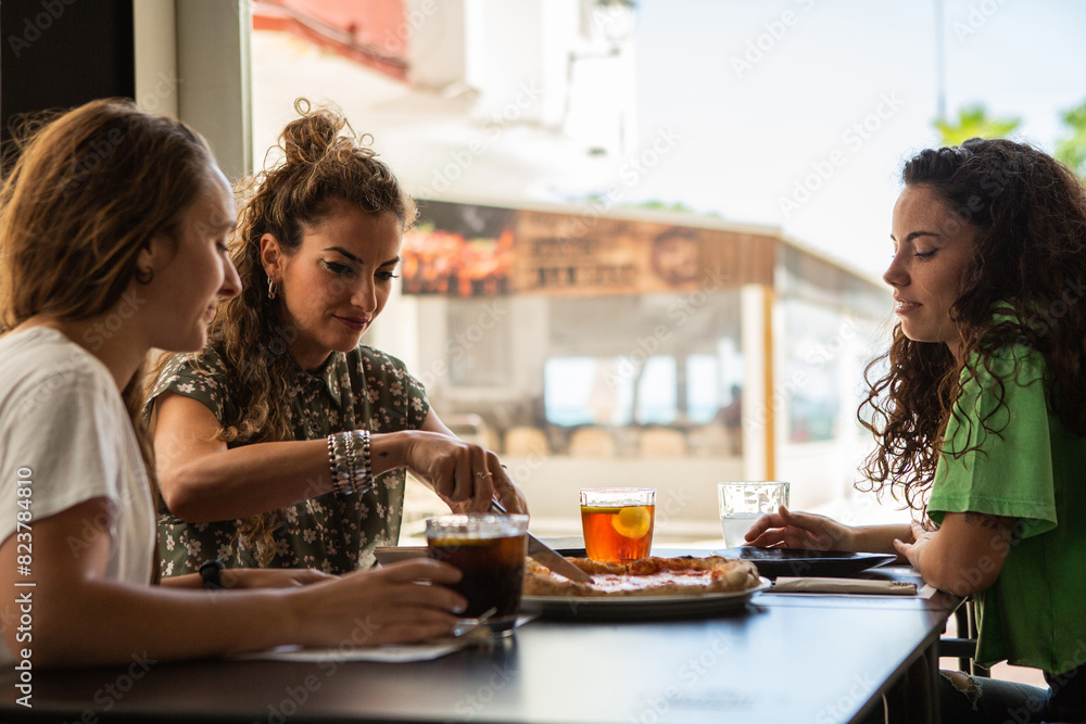 Three friends eat Pizza at a cafe Three friends eat Pizza at a cafe
