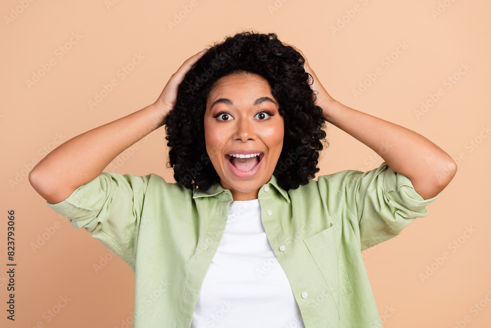Photo of nice young woman hands touch head wear green shirt isolated on beige color background Photo of nice young woman hands touch head wear green shirt isolated on beige color background