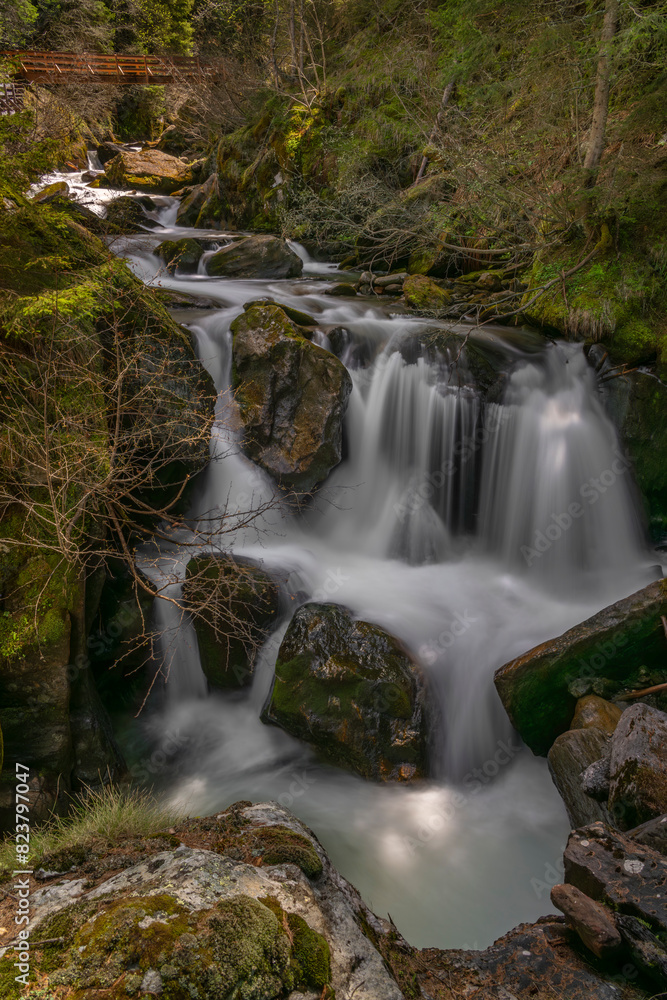 Spring creek under Simplonpass with waterfall in sunny day