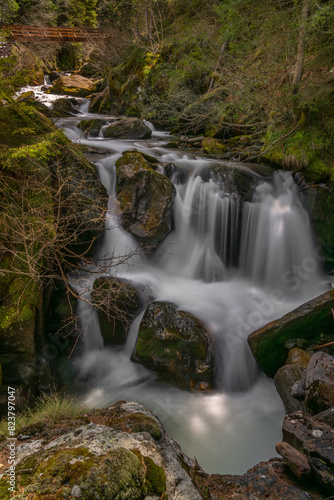 Spring creek under Simplonpass with waterfall in sunny day