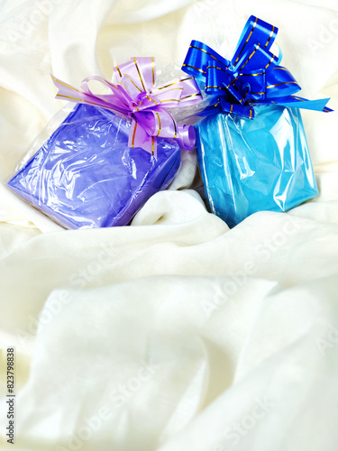 Beautiful colored present boxes with tied ribbon on the tissue background and copy space. Gift giving concept
