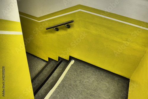 Bright Yellow Stairwell With Black Steps photo