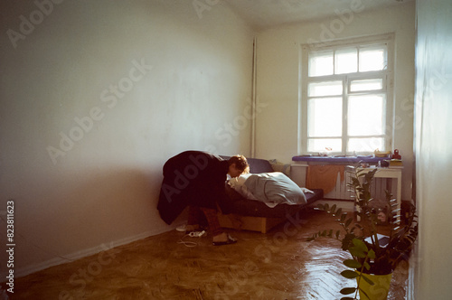 Artist student in his room deploying unfolding the bed sofa  photo