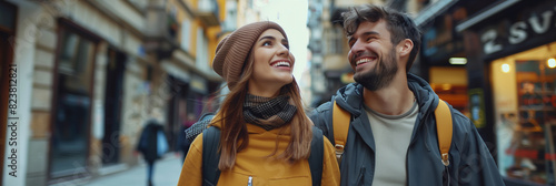 Young Caucasian couple smiling and walking along the street together with backpacks in Europe.