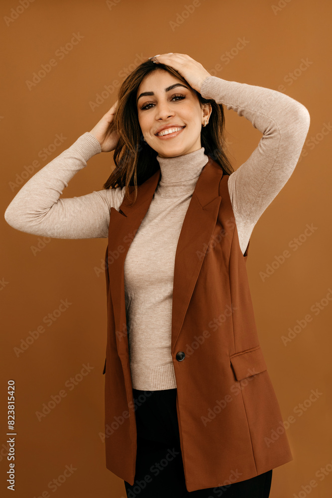 Stylish woman touching hair and standing in studio Stylish woman touching hair and standing in studio