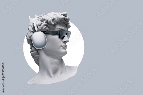 Creative hipster bust statue with fashion sunglasses and headphones on gray background, concept. Creative idea and modern art. photo