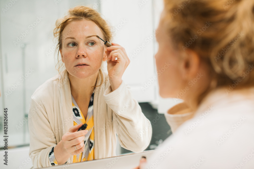 Woman doing eyebrow make up at home Woman doing eyebrow make up at home