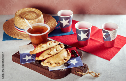 empanadas de pino y mote con huesillos junto a vasos con bandera de Chile, celebración fiestas patrias de Chile photo