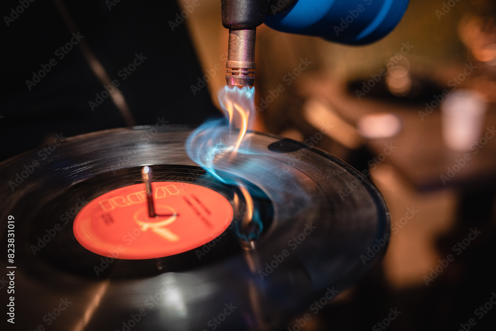 Disco di vinile bruciato da una fiamma, plastica nera che si scioglie mentre gira sul giradischi Disco di vinile bruciato da una fiamma, plastica nera che si scioglie mentre gira sul giradischi