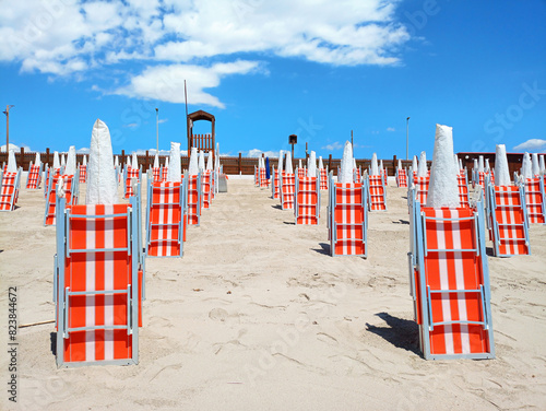 Closed deckchairs and umbrellas on a beach, a symbolic image of the preparations for the summer tourist season
